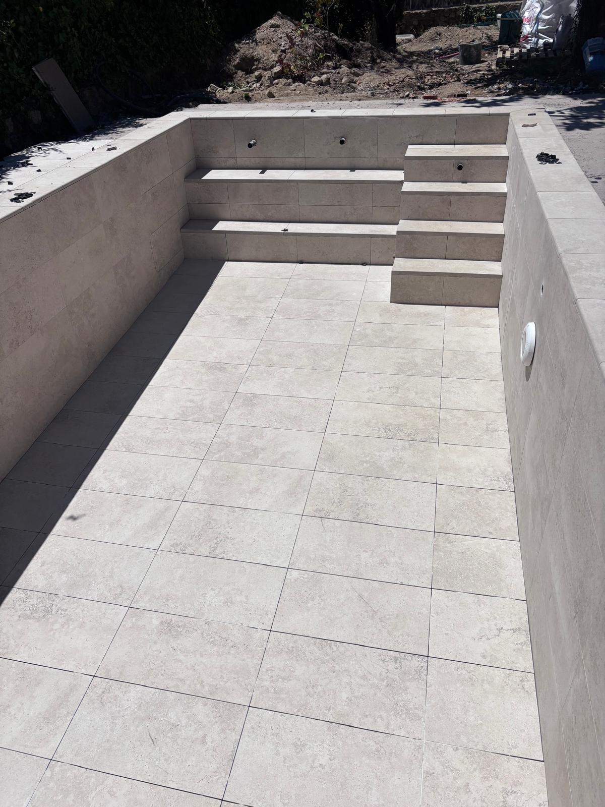 Piscina de hormigón en construcción. Obra con revestimiento, escaleras y lista para impermeabilización.