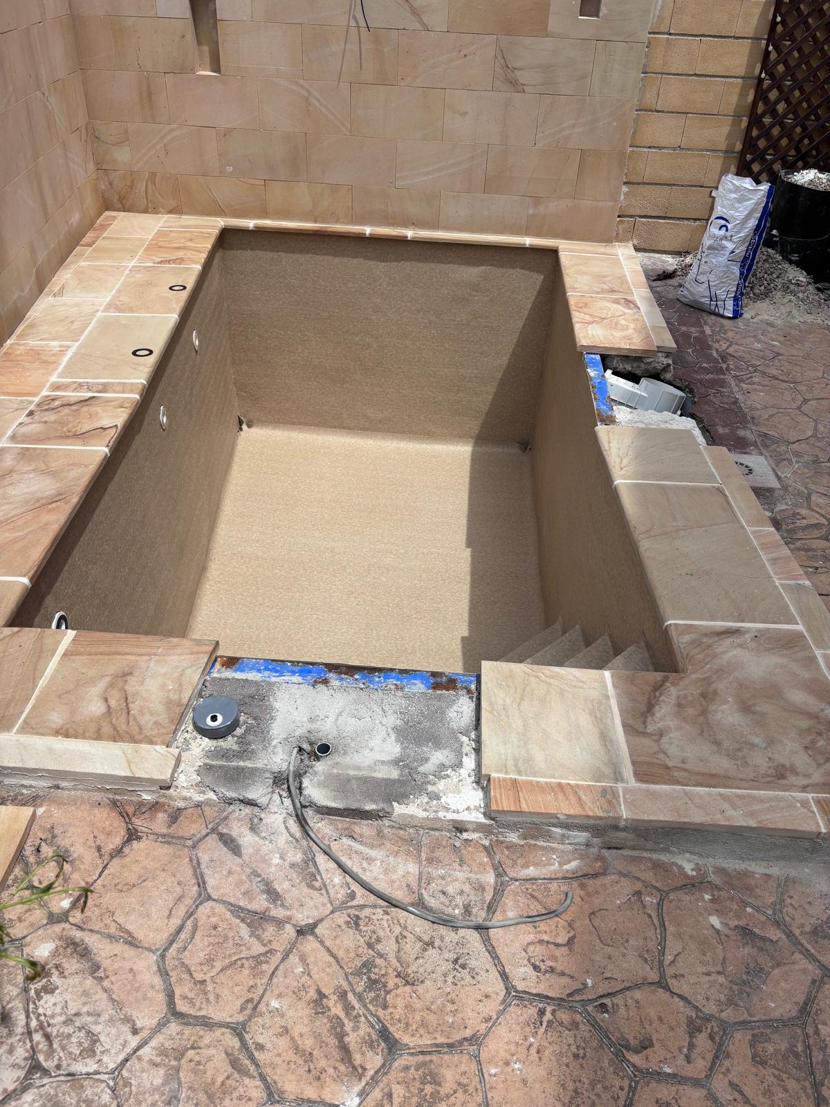 Piscina de hormigón en construcción. Proceso de impermeabilización. Obra de calidad.