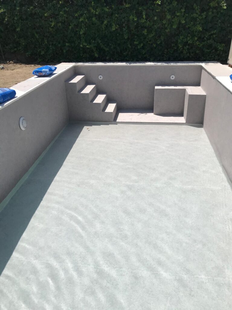 Obra de construcción de piscina de hormigón con escaleras. Impermeabilización profesional.
