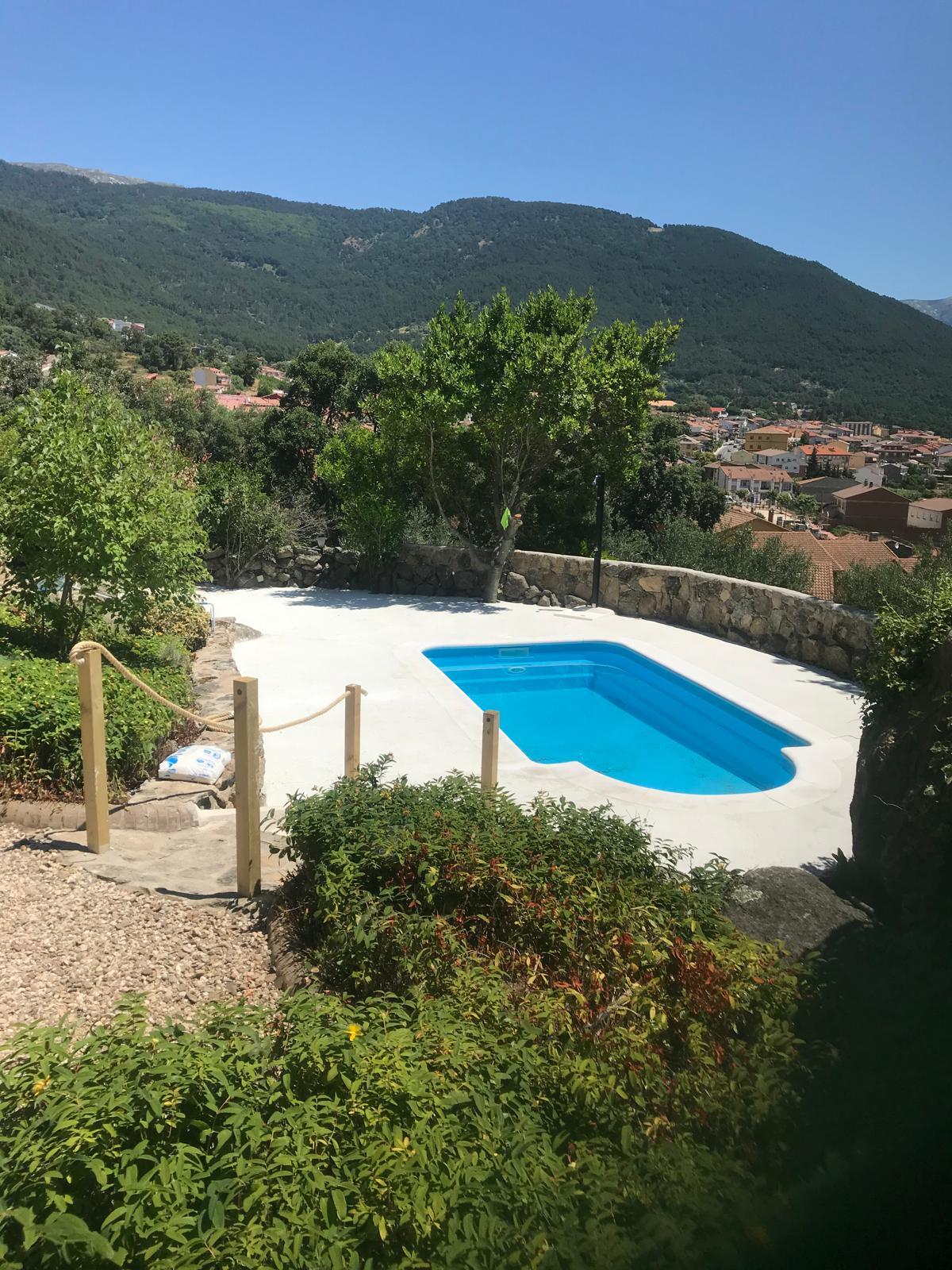 Piscina de hormigón recién construida con impermeabilización, obra de calidad con vistas a la montaña.
