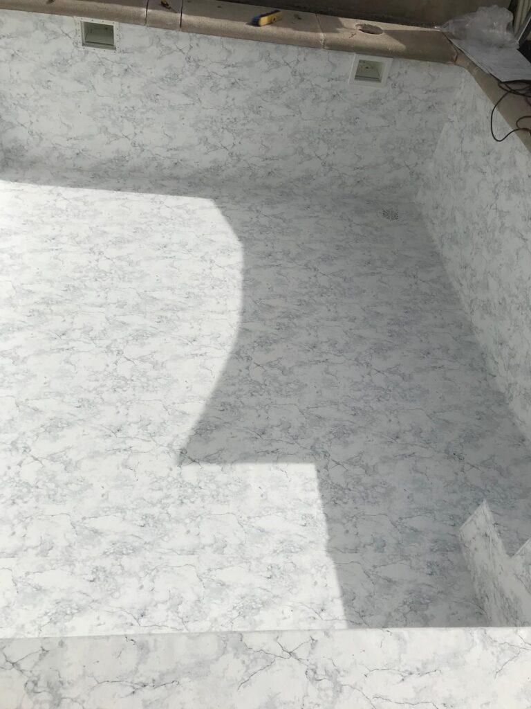 Construcción y obra de piscina de hormigón. Impermeabilización con revestimiento tipo mármol.