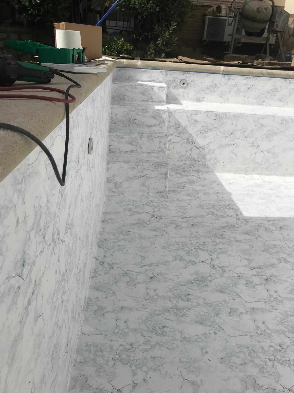 Construcción y obra de piscina. Impermeabilización de hormigón con revestimiento de piscina tipo mármol.