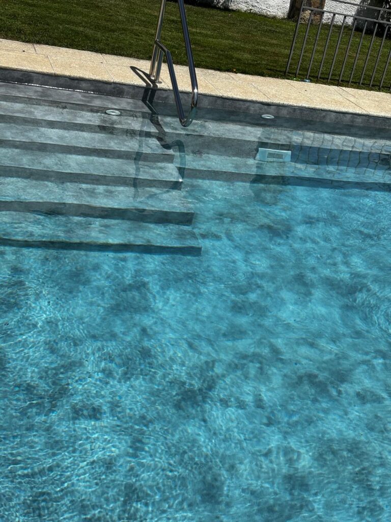 Piscina de hormigón con escaleras, resultado de una obra de construcción e impermeabilización de calidad.