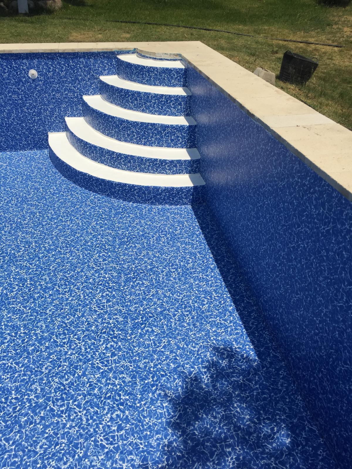 Piscina de hormigón recién construida con impermeabilización azul y escaleras. Especialistas en obra e impermeabilización.