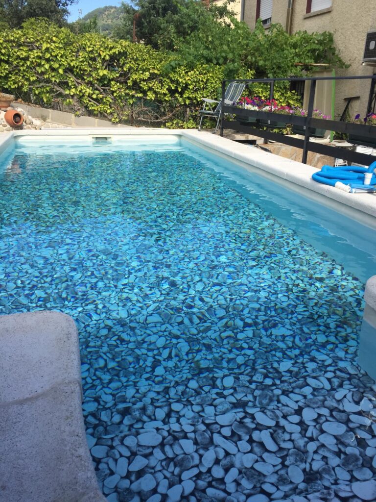 Proyectos de construccion de piscinas. Construcción de piscina de hormigón e impermeabilización. Obra con fondo de guijarros y agua limpia.