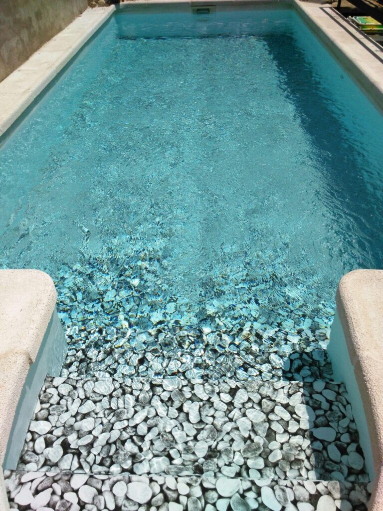 Proyectos de construccion de piscinas. Piscina de hormigón con escaleras de piedra. Expertos en construcción e impermeabilización de piscinas y obra.